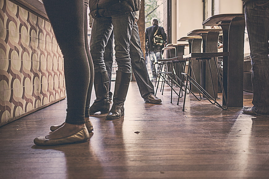 Low angle view of people's legs and shoes in a cafe