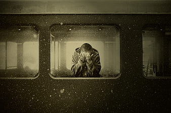 Lonely woman crying in train window during snowfall