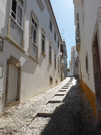 Narrow cobblestone street in white Portuguese village