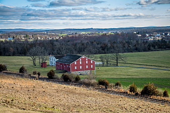 Red Barn and White House in Rural Landscape with Train Tracks
