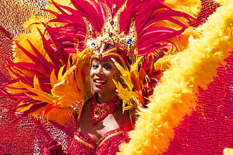 Woman in vibrant red and yellow carnival feather costume