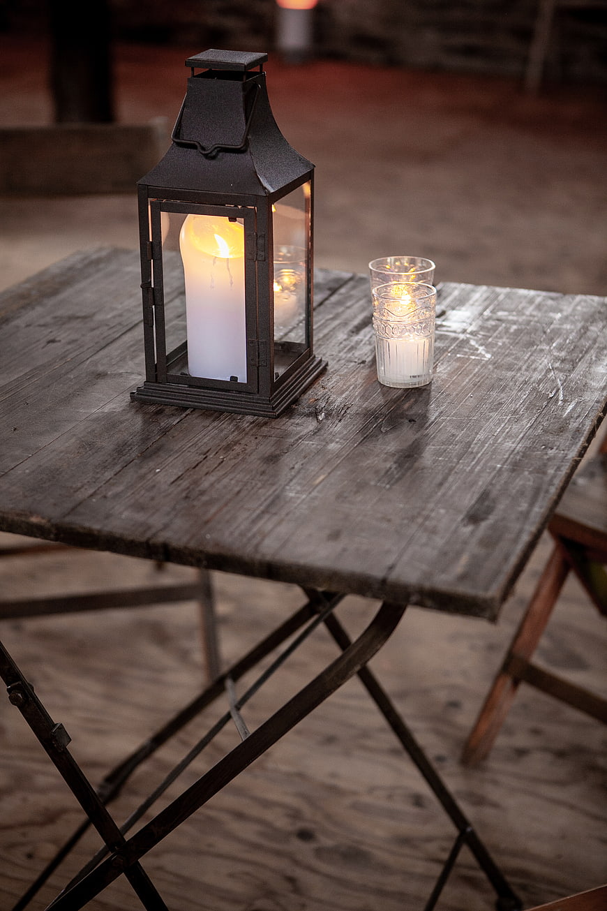 Rustic lantern and candle on weathered wooden table