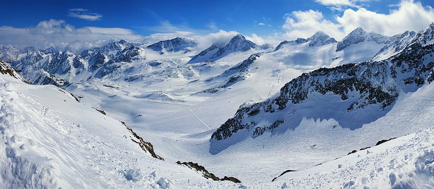 Panoramic View of Snow-Covered Mountain Peaks and Glacier