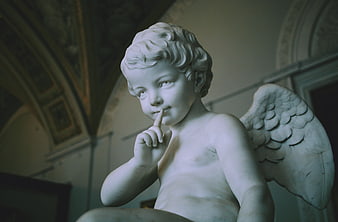 Marble Angel Statue with Finger on Lips in Museum
