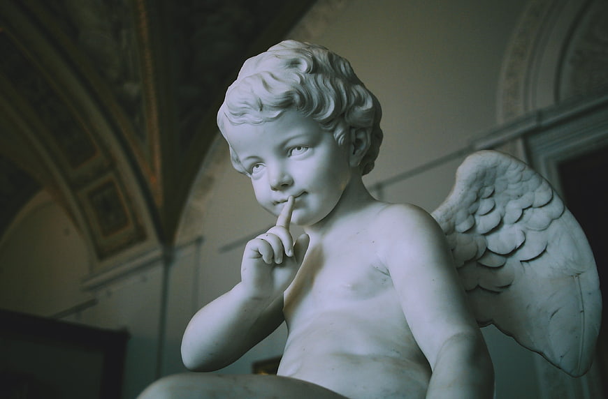 Marble Angel Statue with Finger on Lips in Museum