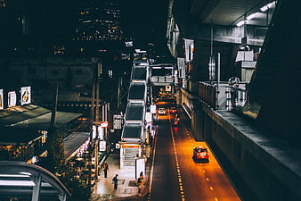 Night urban street scene with elevated train station and traffic