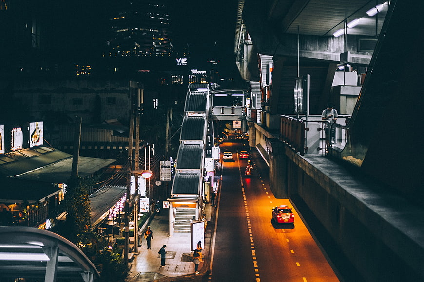 Night urban street scene with elevated train station and traffic