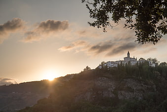 Sunset over hilltop village with church in San Marino