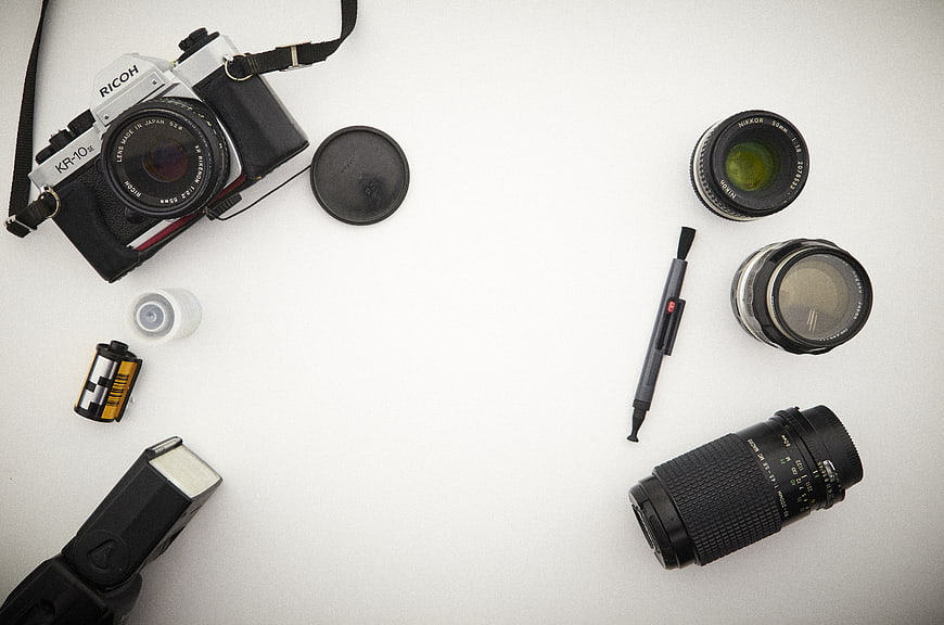 Vintage film camera gear flat lay on white background
