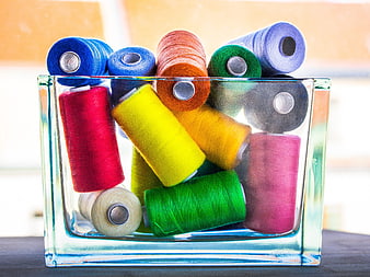 Colorful Sewing Thread Spools in Glass Container