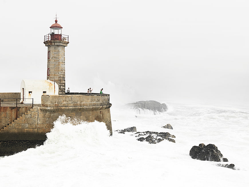 Lighthouse on Stormy Coast with Crashing Waves