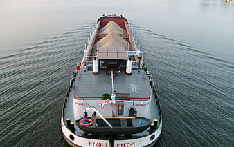 Aerial view of cargo barge transporting sand on river