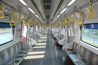 Empty modern subway car interior with yellow hand grips