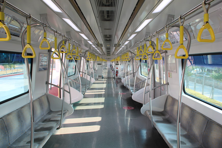 Empty modern subway car interior with yellow hand grips