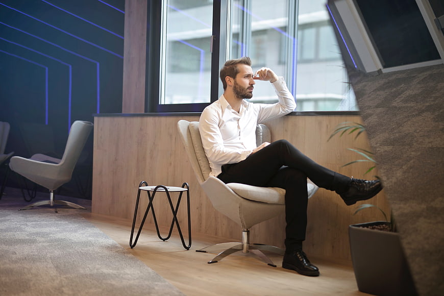Thoughtful businessman sitting in modern office lounge