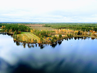 Aerial View of Serene Lake with Autumn Forest and Cabin