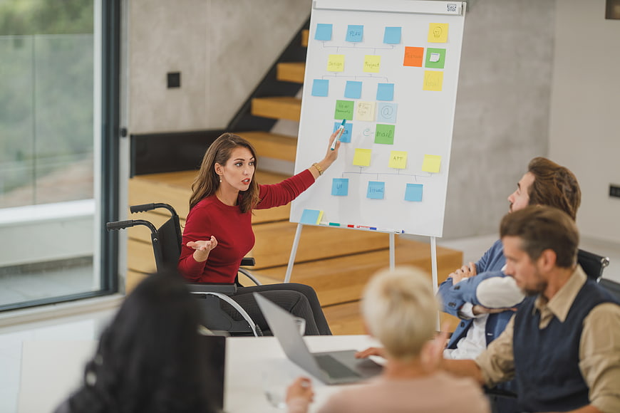 Woman in wheelchair leading business meeting with team