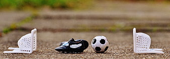 Miniature Soccer Goals, Ball, and Cleats on Gravel