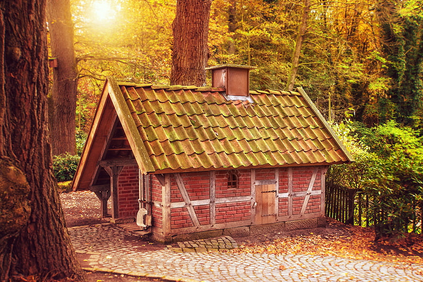 Charming Brick Cottage In Autumn Forest With Tile Roof