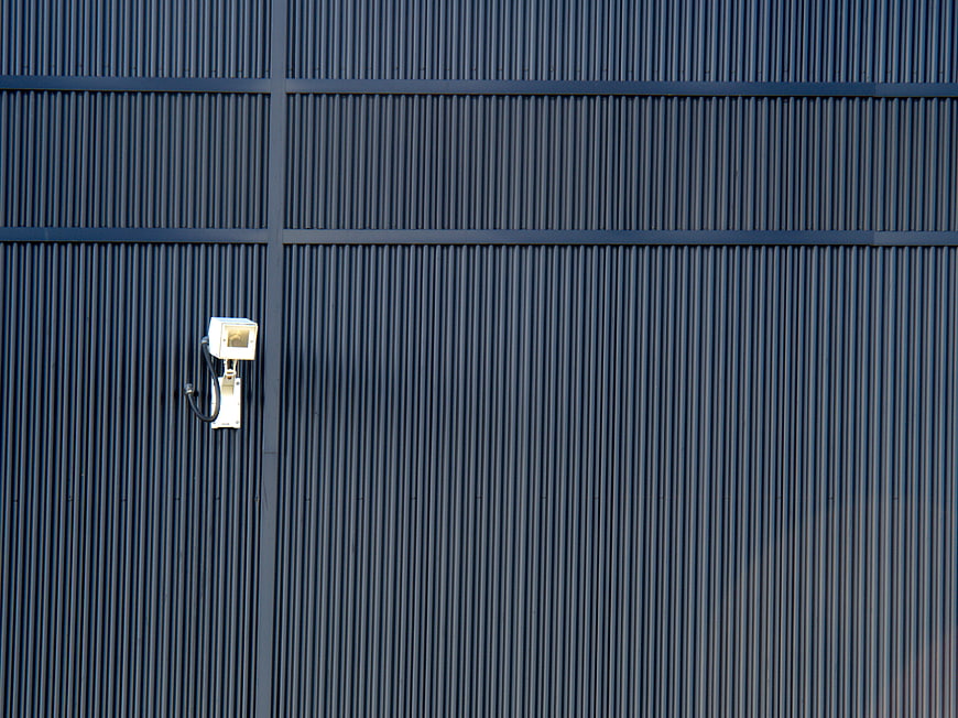 Security Camera on Blue Corrugated Metal Wall