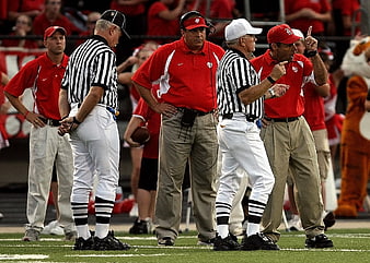 Football coaches arguing with referees on the field