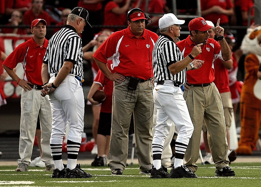 Football coaches arguing with referees on the field