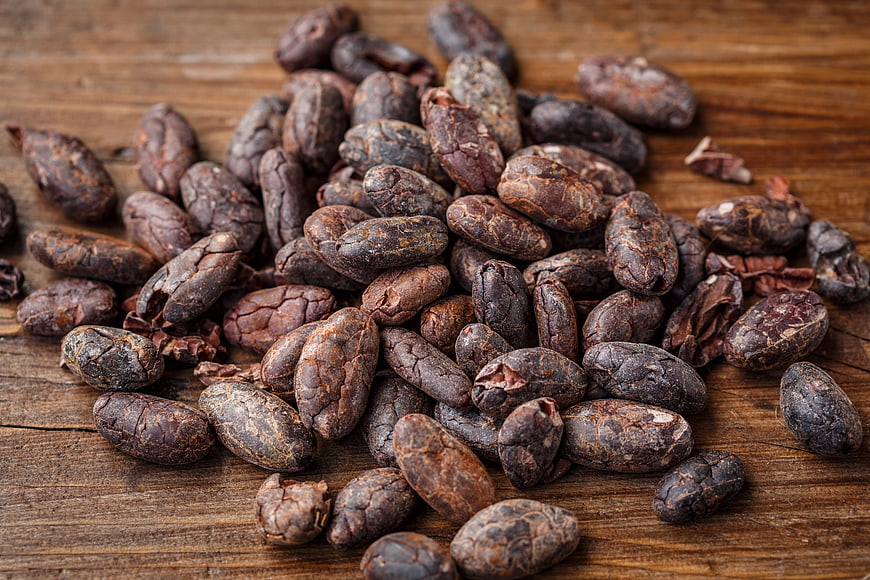 Raw cacao beans on rustic wooden background