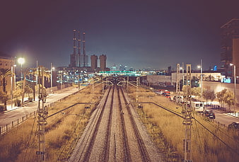 Night view of railway tracks leading to industrial power plant