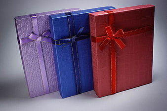 Three Colorful Gift Boxes with Ribbons on Gray Background