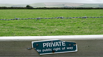Private Property Sign on Wooden Fence with Barbed Wire