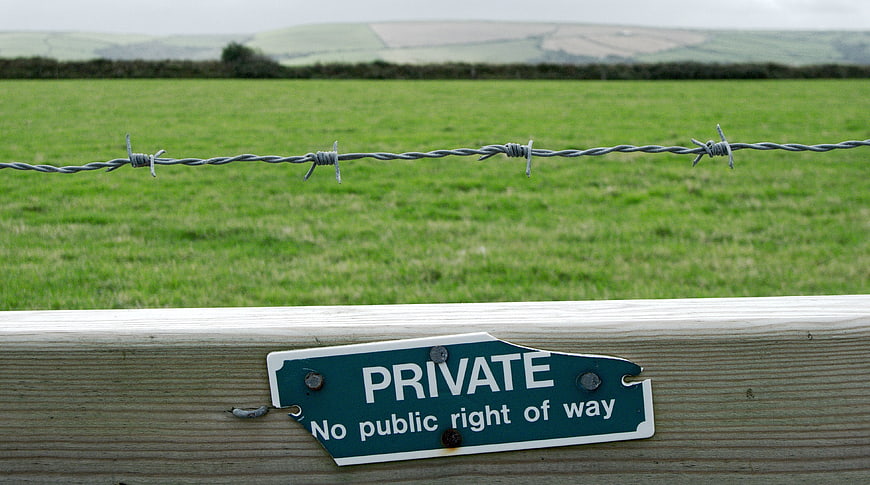 Private Property Sign on Wooden Fence with Barbed Wire