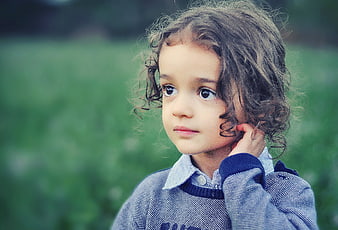 Portrait of Cute Little Girl with Curly Hair Outdoors