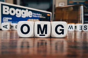 OMG spelled with Boggle letter cubes on wooden table