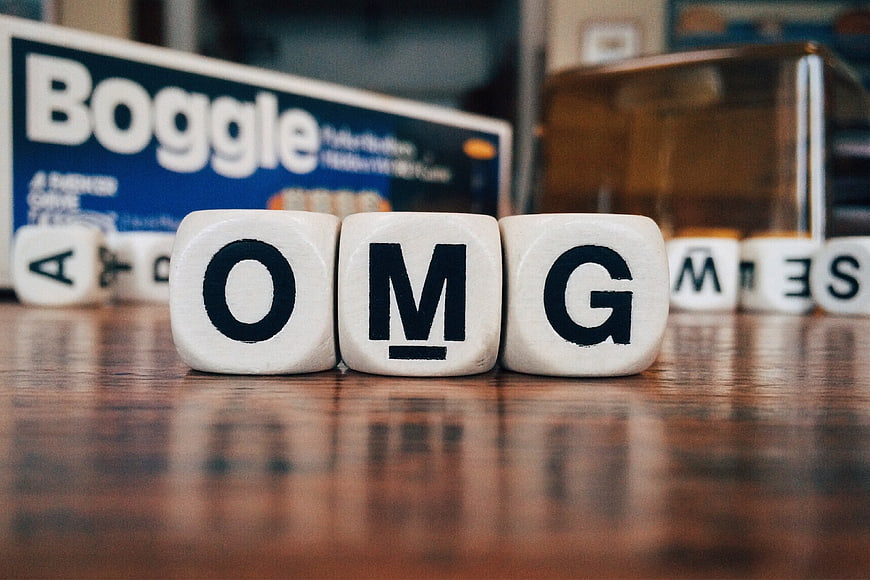 OMG spelled with Boggle letter cubes on wooden table