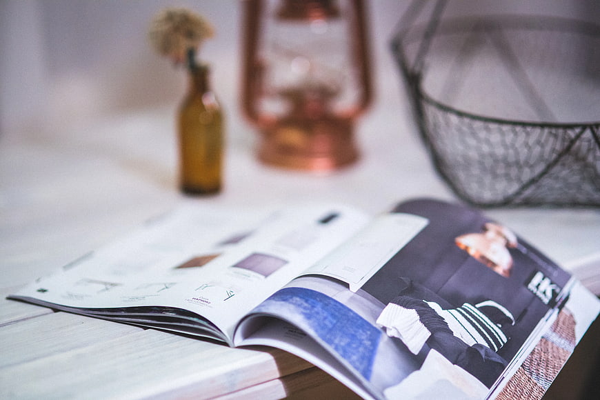 Open magazine on wooden table with blurred background