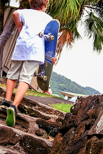 Young Boy Walking Up Steps with Skateboard