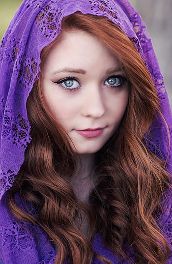 Portrait of young woman with red hair and purple lace headscarf