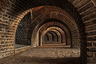 Ancient stone vaulted cellar with repeating brick arches