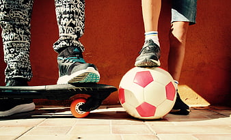Children playing with skateboard and soccer ball outdoors