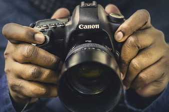 Close-up of Hands Holding a Canon DSLR Camera