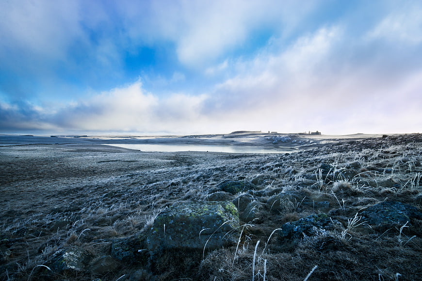 Frosty Aubrac Landscape with Frozen Pond and Distant Buron