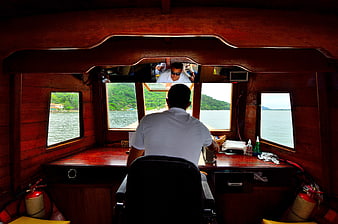 Boat Captain Steering from Wooden Cabin Interior