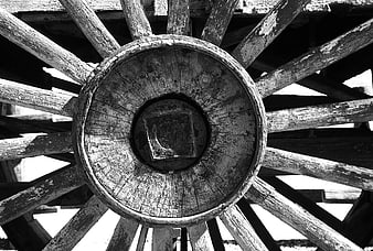 Close-up of vintage wooden carriage wheel hub in black and white