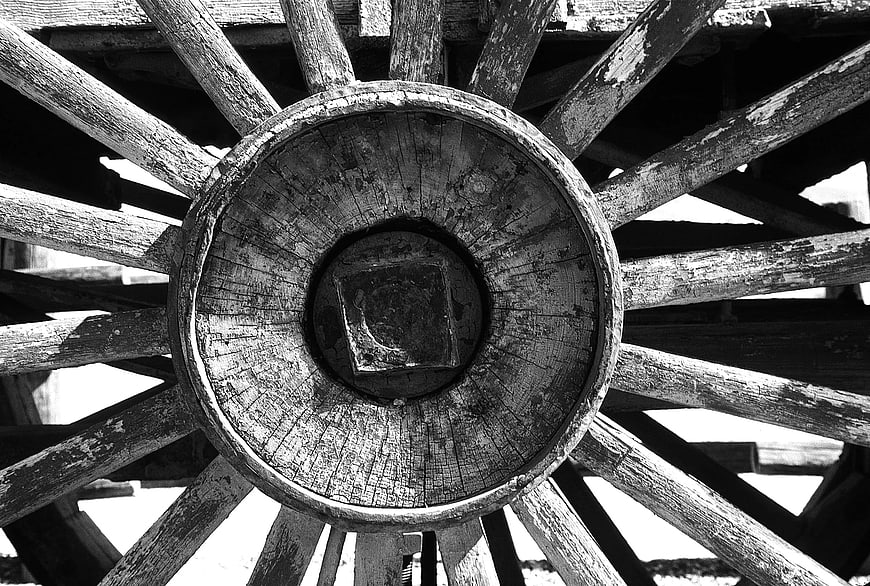 Close-up of vintage wooden carriage wheel hub in black and white