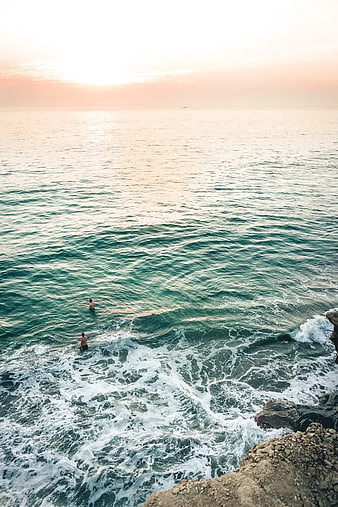 High Angle View of Two People Swimming in Ocean at Sunset