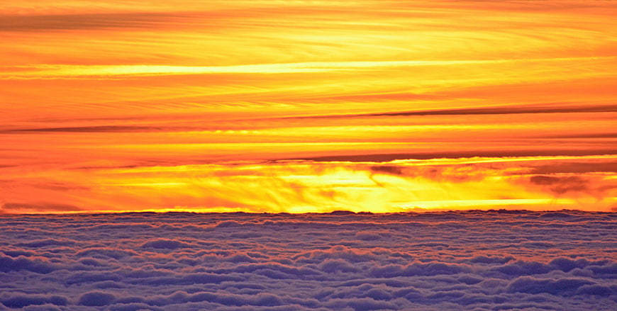 Vibrant Orange Sunset Above Sea of Clouds