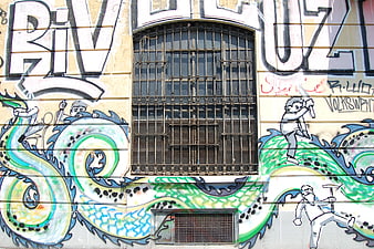 Colorful graffiti mural with dragon and figures on building wall