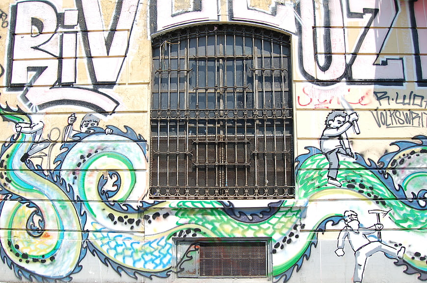 Colorful graffiti mural with dragon and figures on building wall