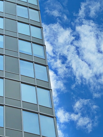 Modern glass office building facade against blue sky