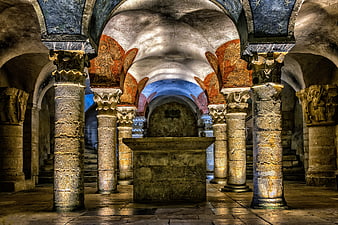 Ancient stone crypt with columns and medieval frescoes